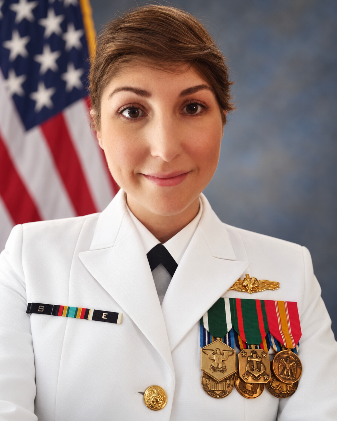 Full portrait of Roxie in Navy dress uniform with the U.S. flag behind her